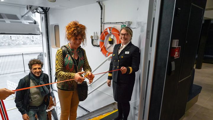 The first passenger on board Havila Polaris cuts the ribbon for the maiden voyage.
