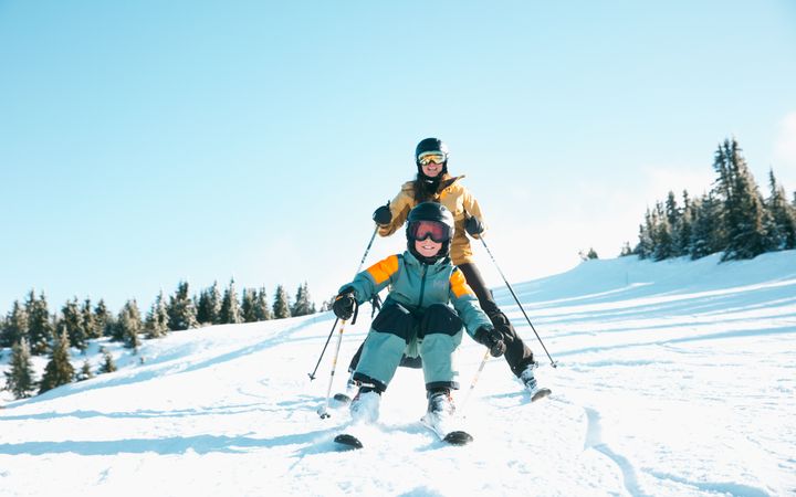 To personer som står på ski i solfylt vinterlandskap.