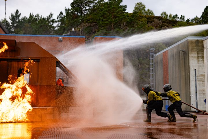 To brannkonstabler løper mot brennende helikopterskrog under øvelse på ny havaritrener på Haakonsvern