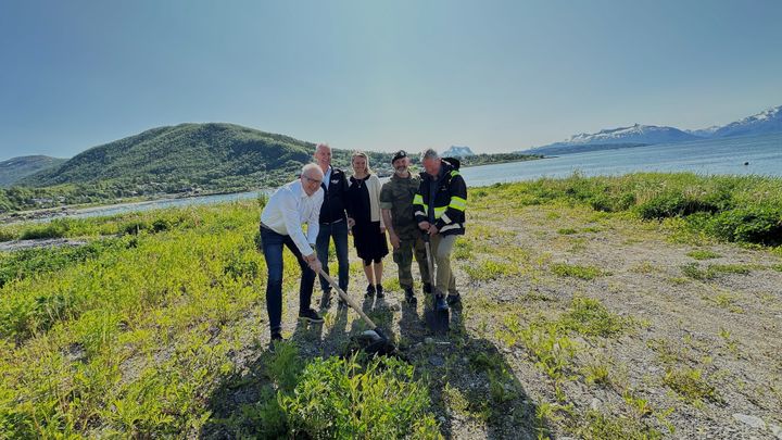 Fem personer står på en grønn tomt ved sjøen, der det skal bygges nye leiligheter for Forsvaret i Bogen, Evenes kommune.