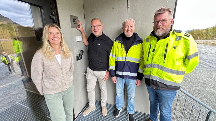 En gruppe personer foran et bygg med Svanemerket-logoen.
