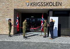 Mann i uniform klipper snor for nytt bygg.