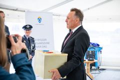 Mann i profil bærer metallboks