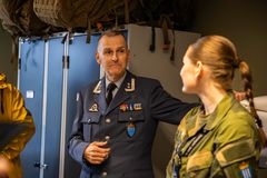 En mann snakker med en kvinne i forsvaret på et kasernerom i Bodø.