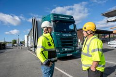 FORNØYDE: Daglig leder Elling Sveen og sjåfør Henning Sand i WoodTrans er begge strålende fornøyd med den nye batterielektriske Scaniaen de tok i bruk etter sommeren.