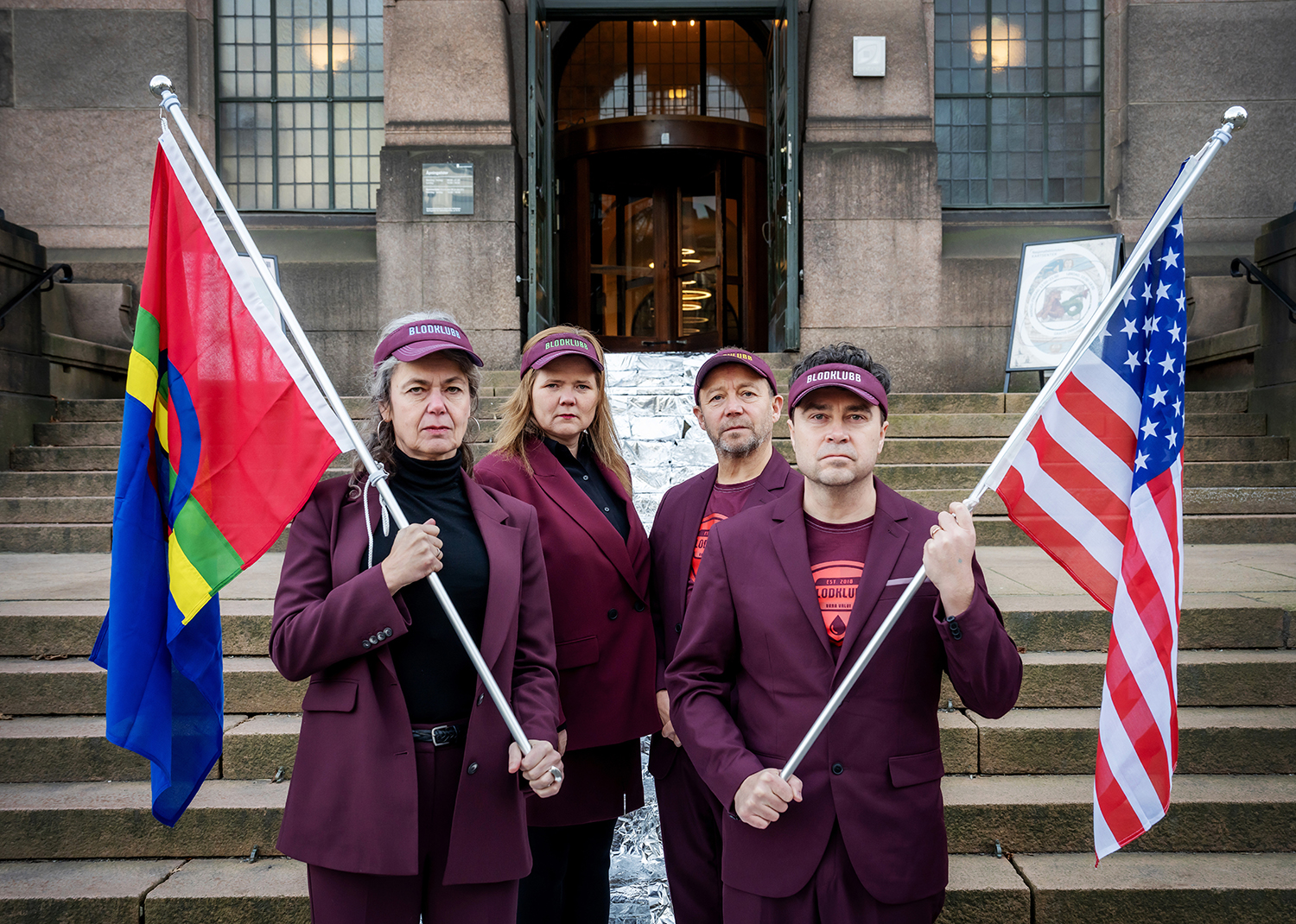 Fire uniformerte personar med samisk og amerikansk flag på trappa til Nasjonalbiblioteket.