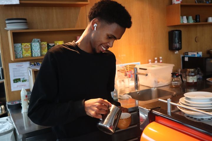 Portrett%20av%20barista%20Ayub%20Ali%20som%20lager%20cappucino%20foran%20kaffemaskin