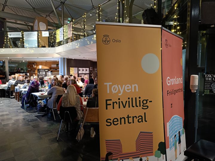 Bilde%20av%20roll%20ups%20med%20T%F8yen%20og%20Gr%F8nland%20frivilligsentral%20foran%20frivillige%20som%20spiser%20sammen