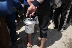Et barn holder et tomt matspann i Nord-Gaza i mai.