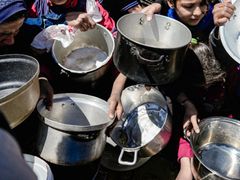 Barn holder tomme gryter utenfor et matutdelingssted i Nord-Gaza.
