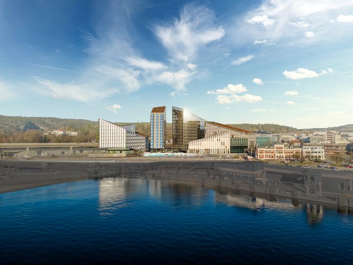 Bilde av Quadrum-parken sett fra sjøen og mot land. Skyline. Store, flotte, moderne bygninger med mange etasjer.