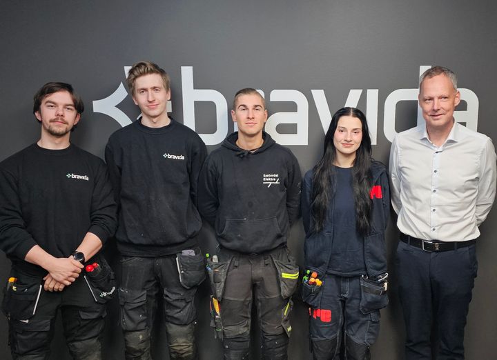 Montørene Sebastian Vetås (Bravida), Lukas Sperstad (Bravida) , Mark Slezin (tidligere Sæterdal Elektro), elektrolærling Sofie Sandal (tidligere Pettersson & Gjellesvik) og regiondirektør for Bravidas nyopprettede region Nordvestlandet, Roy Sætre har vært spente og gjort grundige forberedelser i lang tid før lørdagens fusjon. De står foran en vegg med en stor Bravida-logo.