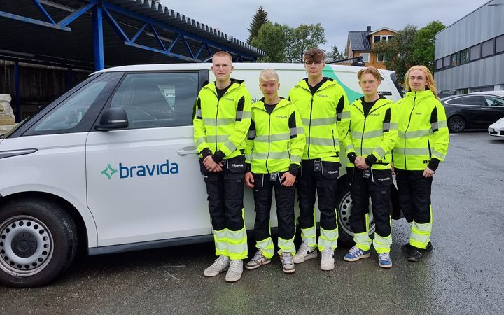 Noen av årets lærlinger i Tromsø står foran en av Bravidas servicebiler.