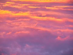 Soloppgangen farger skyene på himmelen i gule, rosa og lilla toner.
