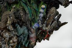 Detalj av skulptur i blå, brun og grønntoner som ligner forstenede vesener i grenselandet mellom organisk og uorganisk liv.