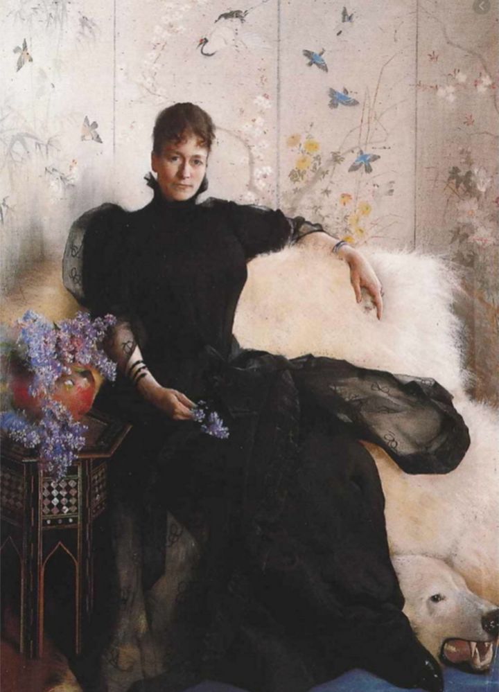 Maleriet%20viser%20en%20kvinne%20kledd%20i%20sort%20kjole%20med%20en%20bl%E5%20syrin%20i%20h%E5nden%20og%20sittende%20p%E5%20en%20hvit%20isbj%F8rnsfell%2C%20som%20har%20isbj%F8rnhode%20med%20%E5pen%20munn.