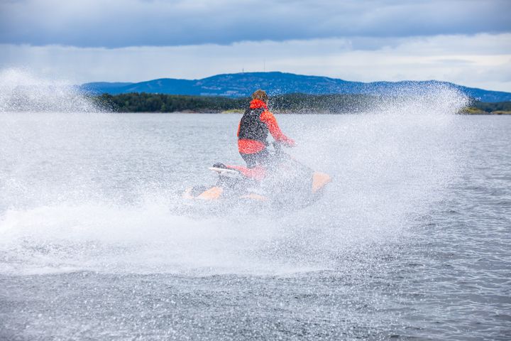En%20person%20kj%F8rer%20en%20vannscooter%20i%20h%F8y%20fart%20p%E5%20sj%F8en.