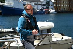 Sjøfartsdirektør Alf Tore Sørheim står ved en fritidsbåt iført redningsvest i et maritimt miljø.