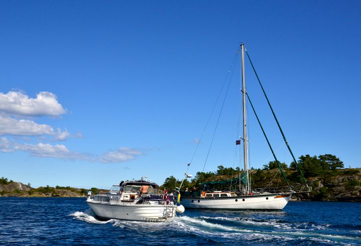 En%20motorb%E5t%20og%20en%20seilb%E5t%20passerer%20hverandre%20i%20rolig%20farvann%20en%20sommerdag.