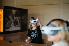 I VR-briller ser jenta Hamardomen slik den var i middelalderen. Bildet er fra historiesenterets åpning i mai 2026.