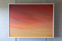 Photography of the sky at sunset coloured by yellow, pink and purple, placed on metal rods in front of a white wall.