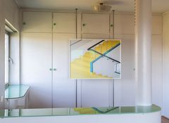 A photograph of a white stairwell in a sanatorium, with yellow steps and black handrail on metal spindles fixed to turquoise base, exhibited in front a wardrobe.
