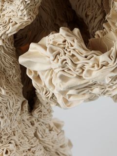 Close up of object in white textile, hanging from the ceiling.