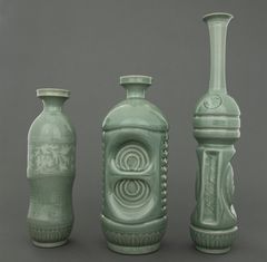 Three green bottles in different shapes, made by glazed ceramics.