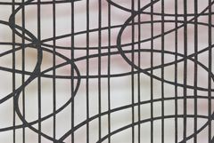 Close up of textile work made by hand-cut, laminated wool felt in a geometrical shape, the colour is black.