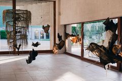 White space with objects made of among others reindeer stomachs, hanging from the ceiling.