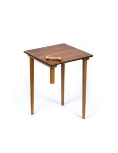 A table lacking half of it's fourth leg, which has been nailed into a dog bone and placed on the table top.