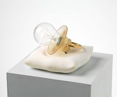 A pacifier made by a light bulb and placed on a marble pillow. When you press the switch it lights up.