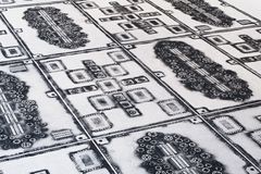 Close up of a carpet made by coal sprinkled over bicycle parts and people's belongins from the site of a fire. It forms an oriental pattern.