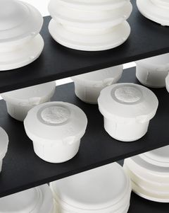 Close up of a shelf with white objects made by bone china, unglazed and white.