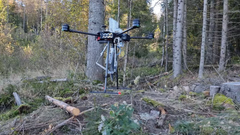 En spesialbygd drone med fire rotorer står klar i skogsterreng.