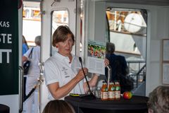 En kvinne holder en rapport og presenterer ved et bord med juiceflasker og et eple.