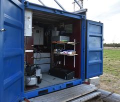 En åpen blå container med utstyr for automatisert overvåking og datainnsamling.