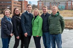 En gruppe mennesker står utendørs foran en bygning.