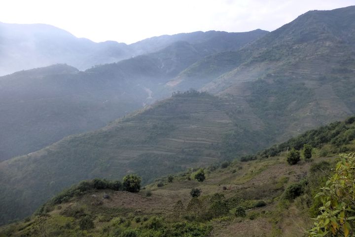 Utsikt langs Yunnan-rute 214, der veien går ned omtrent 1500 meter over en strekning på 38 km, fra landsbyen Potou mot Red River-dalen. Potou township, Yunnan.
