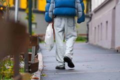 Mann som går med plastpose, høst