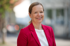 Person med rød jakke smiler.