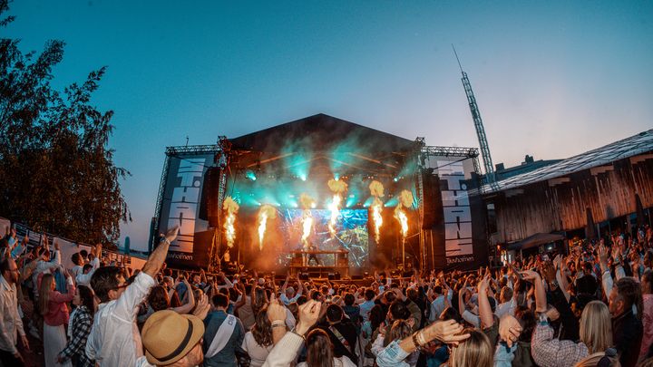Mennesker danser foran en scene med fyrverkeri og lys under St.hans Tjuvholmen 2025.