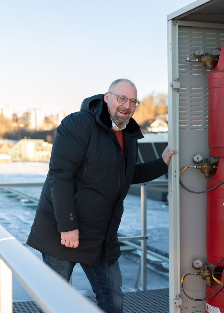 Georg Svendsen, leder for infrastruktur i Telia Norge, foran den hydrogendrevne reservestrømsløsningen på taket av Telias tidligere lokaler i Nydalen.