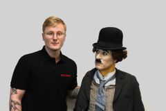 Fredrik Moskvill Sørensen sammen med voksdukke av Charlie Chaplin