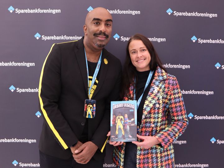 Tegneserieskaper Josef Yohannes og Therese Riiser, administrerende direktør i Sparebankforeningen, holder en utgave av The Urban Legend: Økonomiutgaven, som lanseres av Sparebankforeningen.