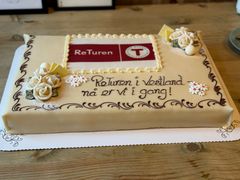 Alternativ tekst: En stor, dekorert kake med teksten "ReTuren i Vestland, nå er vi i gang!"