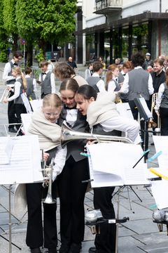 Unge korpsmusikere søker ly for duskregnet før Kronprinsens ankomst. Korpsene som spilte for Kronprinsen og statsministeren av Manger Skulemusikklag og Knarvik Skulekorps.