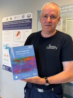 En mann holder en IPCC-rapport om klimaendringer.