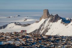Forskere fra Norsk Polarinstitutt foran fjellformasjonen Jutulsessen i et snødekt Antarktis-landskap.