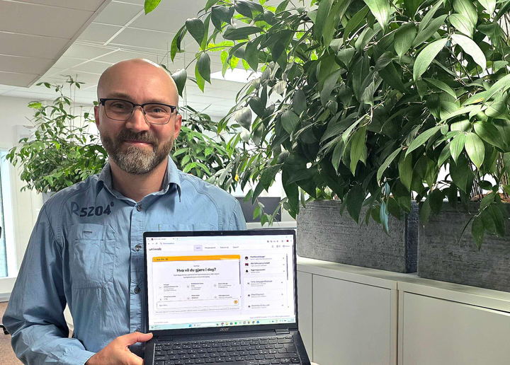 Utvikleren Jørn Jensen viser frem Uniwebs nye KI-assistent Spør Aida på en laptop. Spør Aida er bygget inn i kundenes kontrollpanel og kan både svare på spørsmål og utføre oppgaver på vegne av kunden.